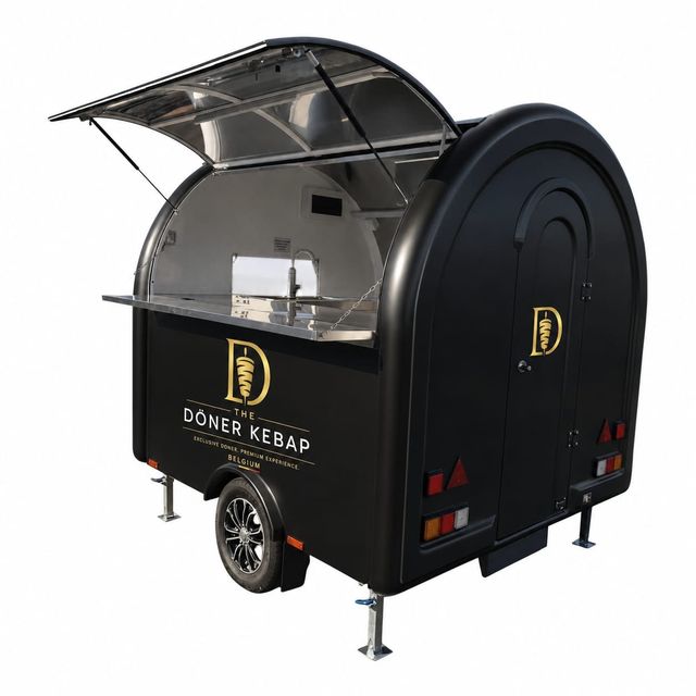 Zwarte foodtrailer met goudkleurig logo, vrijstaand op een witte achtergrond